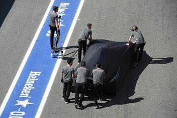 Mecánicos de McLaren empujan el coche de Alonso hasta el box del equipo.