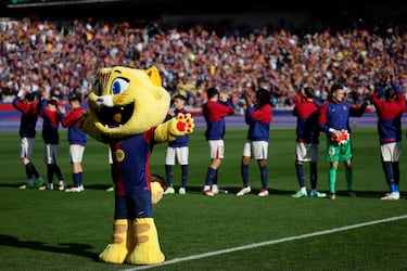 'Cat', la mascota del 125 aniversario del FC Barcelona, saluda al público a la vez que los futbolistas del FC Barcelona.