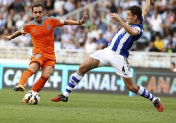 El centrocampista de la Real Sociedad Gorka Elustondo (d) lucha un balón con el delantero del Valencia Paco Alcácer (i), durante el partido de la sexta jornada de Liga de Primera División, disputado esta tarde en el estadio de Anoeta.