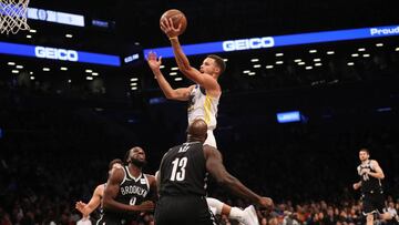 Stephen Curry deja una bandeja ante varios jugadores de los Nets.