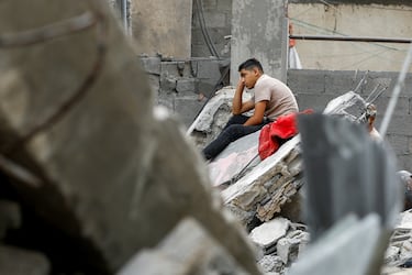 Un joven palestino reposa sobre los escombros de una casa destruida en Rafah, una ciudad de Palestina en la Franja de Gaza.