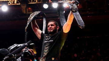 Islam Makhachev levantando sus dos cinturones.