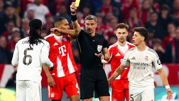MUNICH (Germany), 15/04/2026.- Referee Slavko Vincic (C) shows yellow card to Eduardo Camavinga (L) of Real Madrid during the UEFA Champions League quarter-finals, 2nd leg match FC Bayern Munich against Real Madrid, in Munich, Germany, 15 April 2026. (Liga de Campeones, Alemania) EFE/EPA/ANNA SZILAGYI