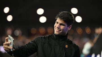 Spain's Carlos Alcaraz gives autographs to fans after the men's singles match against Serbia's Miomir Kecmanovic on day nine of the Australian Open tennis tournament in Melbourne on January 22, 2024. (Photo by Anthony WALLACE / AFP) / -- IMAGE RESTRICTED TO EDITORIAL USE - STRICTLY NO COMMERCIAL USE --