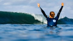 Una surfista levanta los brazos frente a una ola durante una competici&oacute;n de la World Surf League.