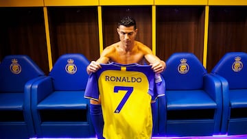 A handout picture released by Saudi Arabia's al-Nassr football club shows Al-Nassr's new Portuguese forward Cristiano Ronaldo holding the club's number seven jersey ahead of his unveiling ceremony at the Mrsool Park Stadium in the Saudi capital Riyadh on January 3, 2023.