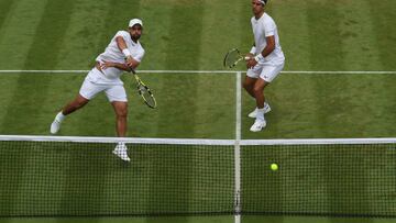 LONDON, ENGLAND - JULY 03: Juan Sebastian Cabal (R) plays a volley with partner Robert Farah of Colombia against Radu Albot of Moldova and Nikoloz Basilashvili of Georgia during their Men's Doubles Third Round match on day seven of The Championships Wimbledon 2022 at All England Lawn Tennis and Croquet Club on July 03, 2022 in London, England. (Photo by Julian Finney/Getty Images)