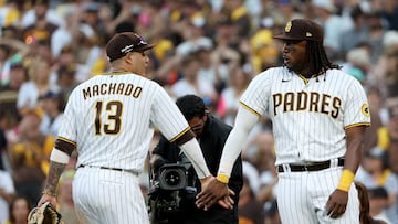 SAN DIEGO, CALIFORNIA - OCTOBER 19: Manny Machado #13 of the San Diego Padres and Josh Bell #24 celebrate defeating the Philadelphia Phillies 8-5 in game two of the National League Championship Series at PETCO Park on October 19, 2022 in San Diego, California.   Harry How/Getty Images/AFP