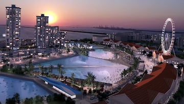 Imagen aérea de Wave Park Korea, con una piscina de olas para el surf con tecnología Wavegarden, otras piscinas, una noria, el sol saliendo y edificios altos al lado.