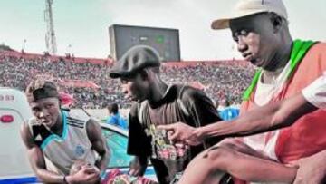 <b>HERIDOS. </b>Unos seguidores ayudan a los sanitarios a socorrer a uno de los heridos