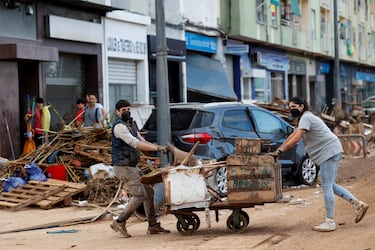 La gente camina por una calle cubierta de barro, tras las fuertes lluvias del pasado 29 de octubre.
