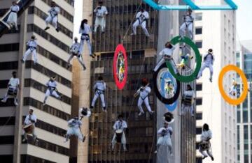 Un grupo de acróbatas actúa durante el paso de la antorcha olímpica por la Avenida Paulista en Sao Paulo, Brasil.