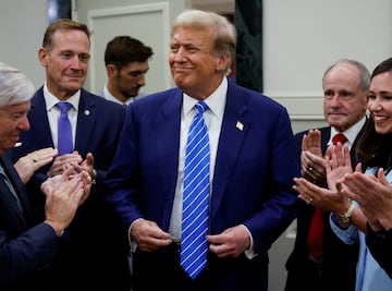 Former U.S. President Donald Trump reacts as he is applauded by Republicans.