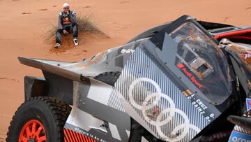 Audi's hybrid Spanish driver Carlos Sainz reacts by his car after a crash during Stage 9 of the Dakar 2023 rally between Riyadh and Haradh in Saudi Arabia on January 10, 2023. (Photo by FRANCK FIFE / AFP)