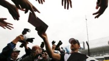 Button firmando autógrafos en el circuito de Suzuka.