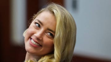 Actor Amber Heard smiles after returning from a break during ex-husband Johnny Depp's defamation trial against her at the Fairfax County Circuit Courthouse in Fairfax, Virginia, on May 18, 2022. - US actor Johnny Depp is suing ex-wife Amber Heard for libel after she wrote an op-ed piece in The Washington Post in 2018 referring to herself as a public figure representing domestic abuse. (Photo by KEVIN LAMARQUE / POOL / AFP) (Photo by KEVIN LAMARQUE/POOL/AFP via Getty Images)