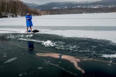 El apneista checo David Vencl nada bajo el hielo durante un entrenamiento en el lago Barbora, cerca de la ciudad de Teplice, para su meta de romper el récord mundial Guinness de la especialidad, que actualmente es de 76,2 metros. Vencl dice que su objetivo es nadar 80 metros.