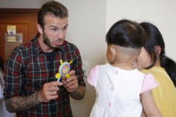 David Beckham durante su visita a China, ha visitado un hospital de Hangzhou, provincia de Zhejiang. Con su habitual carisma saluda a una niña enferma del corazón con un gesto cariñoso.