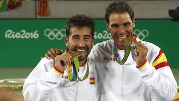 Marc López y Rafa Nadal muerden la medalla de oro lograda en dobles en los Juegos Olímpicos de Río.
