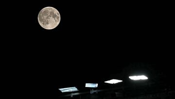 A full moon, this one also called The Harvest Moon, and one of 4 supermoons this year, is pictured rising above the lights at Old Trafford in Manchester, north west England, on September 17, 2024, during the English League Cup third round football match between Manchester United and Barnsley. Supermoons happen when the moon is closest to earth, and appear bigger than usual. (Photo by Paul ELLIS / AFP) / RESTRICTED TO EDITORIAL USE. No use with unauthorized audio, video, data, fixture lists, club/league logos or 'live' services. Online in-match use limited to 120 images. An additional 40 images may be used in extra time. No video emulation. Social media in-match use limited to 120 images. An additional 40 images may be used in extra time. No use in betting publications, games or single club/league/player publications. /