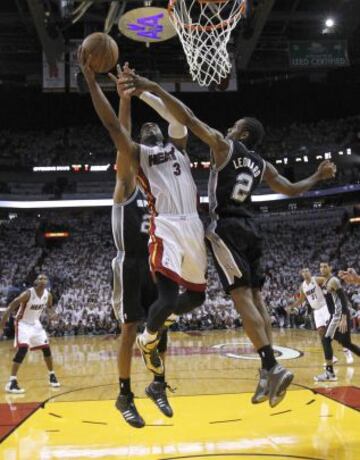 Miami Heat 95 (4) - San Antonio Spurs 88 (3). Dwyane Wade intenta anotar entre Kawhi Leonard y Tim Duncan.