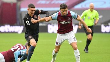 West Ham United's English defender Aaron Cresswell (R) holds off Manchester City's English midfielder Phil Foden during the English Premier League football match between West Ham United and Manchester City at The London Stadium, in east London o