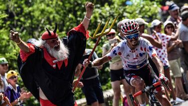 (FILES) In this file photograph taken on July 25, 2018, France's Julian Alaphilippe, wearing the best climber's polka dot jersey (R) seizes the fork of Tour de France fan Didi Senft (L) during the 17th stage of the 105th edition of the Tour de France cycl