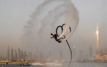 Un atleta realiza acrobacias con un propulsor de chorro de agua el primer día del festival de deportes acuáticos de Dubái, organizado por el Dubai International Marine Club (DIMC), cerca del rascacielos Burj Khalifa en el emirato del Golfo.