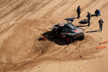 El piloto de Audi, Carlos Sainz, y el copiloto, Lucas Cruz, caminan alrededor de su automóvil después de su accidente durante la Etapa 6 del Dakar 2023 entre Ha'il y Al Duwadimi.
