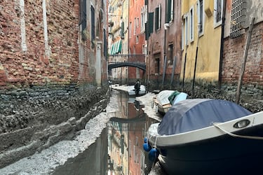 Barcos atracados a lo largo de un canal durante una marea baja en Venecia, Italia, el lunes 20 de febrero de 2023. Algunos de los canales secundarios de Venecia prácticamente se han secado últimamente debido a un período prolongado de mareas bajas vinculado a un sistema climático persistente de alta presión.