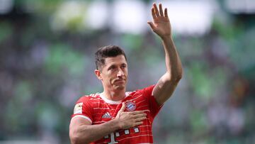 Bayern Munich's Polish forward Robert Lewandowski greets and holds a hand on his heart after the German first division Bundesliga football match VfL Wolfsburg v Bayern Munich in Wolfsburg, northern Germany, on May 14, 2022. (Photo by Ronny Hartmann / AFP) / DFL REGULATIONS PROHIBIT ANY USE OF PHOTOGRAPHS AS IMAGE SEQUENCES AND/OR QUASI-VIDEO