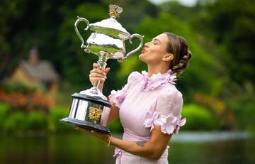 Aryna Sabalenka besando el trofeo de campeona del Abierto de Australia en los Jardines Reales de Melbourne.