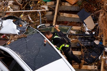 Un miembro de la Guardia Civil Española busca a las víctimas en un coche tras las fuertes lluvias en Alfafar, en Valencia.