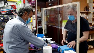 Toni (d), empleado de una ferreteria, atiende a un cliente. EFE/Toni Albir/Archivo