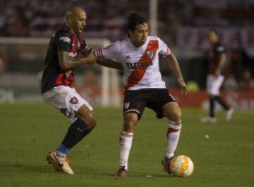 El jugador de River Plate Leonardo Pisculichi (d) disputa el balón con Juan Mercier (i) de San Lorenzo en el partido de ida de la final de la Recopa Sudamericana.