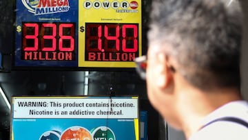 Una persona pasa junto a un cartel electrónico que muestra el premio mayor de $1,4 billones de dólares del sorteo de la lotería Powerball.