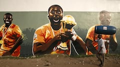 A man walks past graffiti of the Ivory Coast captain Yaya Toure with the 2015 Africa Cup of Nations trophy in Treichville district