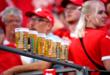 Una vista detallada de unos vasos de cerveza descansando sobre una barandilla dentro del estadio Frankfurt Arena.
