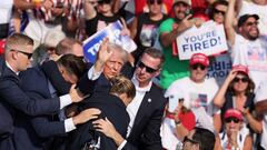 FILE PHOTO: Republican presidential candidate and former U.S. President Donald Trump gestures with a bloodied face while he is assisted by U.S. Secret Service personnel after he was shot in the right ear during a campaign rally at the Butler Farm Show in Butler, Pennsylvania, U.S., July 13, 2024. REUTERS/Brendan McDermid/File Photo