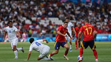 PARÍS (FRANCIA), 24/07/2024.- El delantero español Fermín López (c) disputa un balón con el defensa uzbeco Khusniddin Alikulov (2i) durante el partido de la fase de grupos de los Juegos Olímpicos que España y Uzbekistán disputan este miércoles en el Parque de los Príncipes de París. EFE/ Miguel Gutiérrez