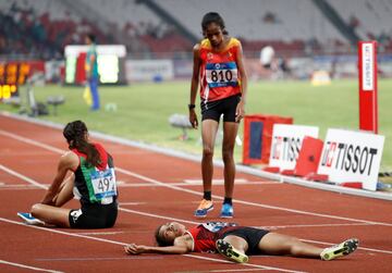 La atleta indonesia Odekta Elvina Naibaho acaba en el suelo tras cruzar la meta de la final de los 5000 metros de los Juegos Asiáticos. 
