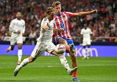 Lula Modric y Marcos Llorente disputan un balón dividido.