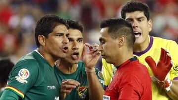 Jun 10, 2016; Foxborough, MA, USA; Bolivia defender Edward Zenteno (22) and defender Luis Gutierrez (3) and goalkeeper Carlos Lampe (1) surround referee Jair Marrufo after he awarded Chile a penalty kick in extra time during the second half of Chile's 2-1 win over Bolivia in the group play stage of the 2016 Copa America Centenario at Gillette Stadium. Mandatory Credit: Winslow Townson-USA TODAY Sports