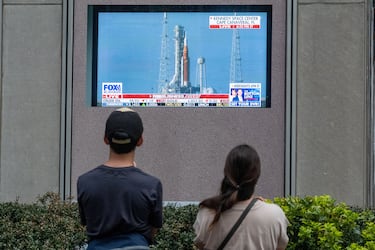 Varias personas observan el lanzamiento de la misión Artemis II de la NASA, que sobrevolará la Luna, en una pantalla en la plaza de News Corp. en Manhattan.