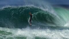 Un surfista, de pie y con las manos levantadas, sale de una ola en forma de tubo en Las Landas (Francia), en un v&iacute;deo de Borja Amondarain.