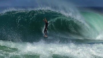 Un surfista, de pie y con las manos levantadas, sale de una ola en forma de tubo en Las Landas (Francia), en un vídeo de Borja Amondarain.
