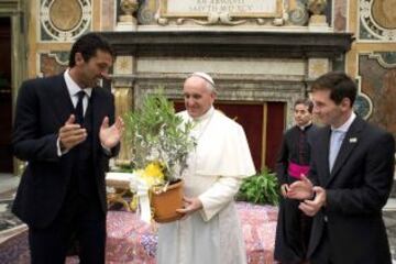 Papa Francisco recibe un regalo del jugador de fútbol de Argentina Lionel Messi y el portero italiano Gianluigi Buffon durante una audiencia privada en el Vaticano