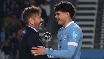 Conmebol President Alejandro Dominguez (L) greets Uruguay's defender Alan Matturro (R) on the podium after Uruguay won the Argentina 2023 U-20 World Cup at the Estadio Unico Diego Armando Maradona stadium in La Plata, Argentina, on June 11, 2023. (Photo by Alejandro PAGNI / AFP)