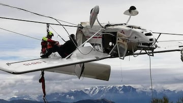 Un miembro del Corpo Nazionale Soccorso Alpino e Speleologico (CNSAS) rescatando al pasajero de la avioneta estrellada en el telesilla de la estaci&oacute;n de esqu&iacute; de Prato Valentino.