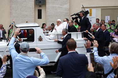 Los fieles saludan al Papa Francisco al paso del papamóvil con Francisco montado en el mismo.